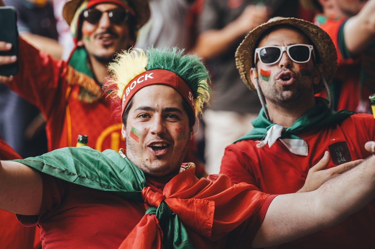 Las Estrellas del Mañana: Conoce a los Talentos de "600 Millones" Passionate group of football fans celebrating outdoors with flags and colorful outfits.